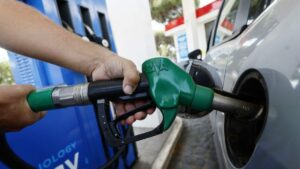 Mano che rifornisce un'auto con la pistola del gasolio