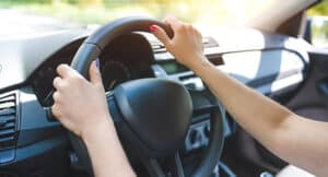 Mani di una guidatrice sul volante durante la guida