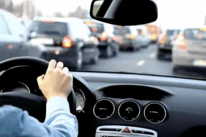Guidatore al volante nel traffico, visto dall'abitacolo