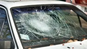 Parabrezza di un'auto bianca con una vistosa crepa a raggiera