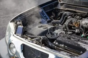 Motore di un'auto che emette fumo dal vano aperto